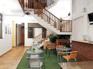 Habitación con mesas, sillas y escaleras. en Hostal Mendieta, en Paracas
