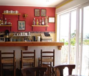 a bar in a restaurant with red walls and chairs at Pensión El Hidalgo in Calpe