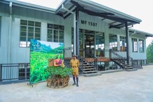 um homem parado em frente a um edifício com um cartaz em Oak Ray Tea Bush em Ramboda