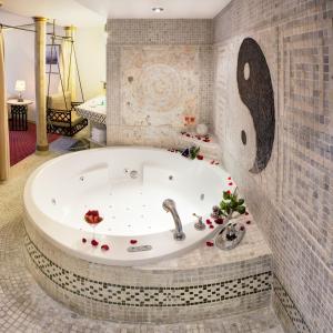 y baño con bañera y pared de azulejos. en Hotel Hoffmeister en Praga