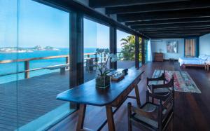 ein Wohnzimmer mit einem Tisch, Stühlen und Meerblick in der Unterkunft CLIFFSIDE - Boutique Hotel & Spa in Rio de Janeiro