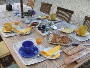 einen Holztisch mit Essen und Brot darauf in der Unterkunft Le Moulin d'Hys in La Cropte
