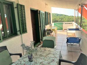a patio with a table and chairs on a balcony at Apartman Juliana in Stara Novalja