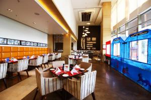 a dining room with tables and chairs in a restaurant at Sayaji Raipur in Raipur