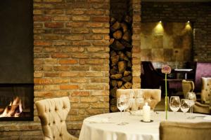 stół z kieliszkami do wina w restauracji z kominkiem w obiekcie Hotel Remes w mieście Opalenica