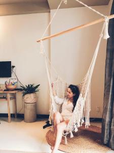 a woman sitting in a hammock in a room at AYA Homestay in Ho Chi Minh City