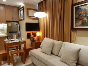 a living room with a white couch and a kitchen at Stay Amare Residences Malate in Manila