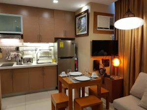 uma cozinha com uma pequena mesa num quarto em Stay Amare Residences Malate em Manila