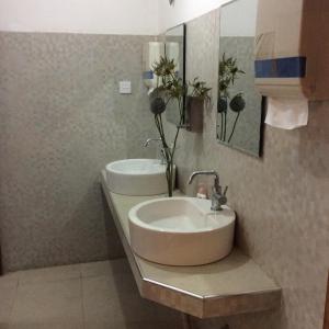 a bathroom with a sink and a mirror and flowers at Hotel Mount Pleasant in Bandarawela