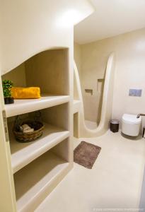 a bathroom with white shelves and a toilet at Aerides Villas in Naxos Chora