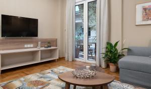 sala de estar con TV, sofá y mesa en Absolute Athens IV en Atenas