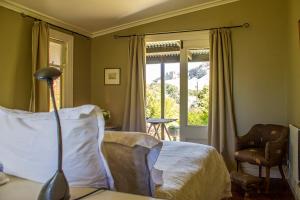 een slaapkamer met een bed, een stoel en een raam bij Secluded Haven Near Bush, Beach & Havelock North in Havelock North