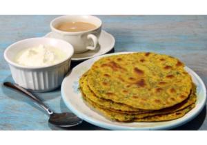 a plate with a stack of pancakes and a cup of coffee at Premier rooms with Rooftop Terrace Restaurant in Nainital