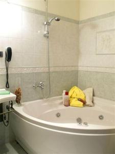 a bathroom with a tub with a shower and a phone at Petit Chateau in Montecatini Terme +37 photos