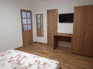 a bedroom with a bed and a desk and a television at Casa Pozitiv Relax in Buzău