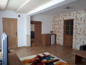 sala de estar con suelo de madera y paredes blancas en Casa Pozitiv Relax, en Buzau