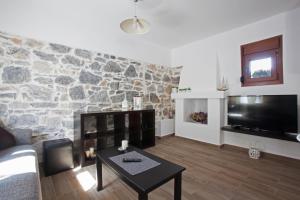 a living room with a fireplace and a stone wall at Antoni's House Makri in Alexandroupoli