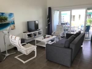 a living room with a couch and chairs and a tv at Blije Rust 10 in Willemstad