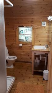 a wooden bathroom with a toilet and a sink at Dalen Gaard camping og hytter in Geiranger