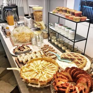 um buffet de tartes e bolos numa mesa em Chery Bed & Breakfast em Riva San Vitale