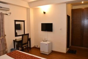 a living room with a white couch and a television at Royalton Hotel Rawalpindi in Rawalpindi