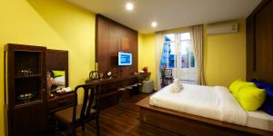 een slaapkamer met een bed, een bureau en een raam bij Sabye Bangkok in Bangkok