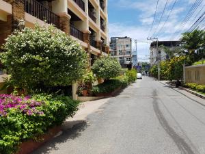 una strada vuota con fiori sul lato di un edificio di Jomtien Beach Residence a Jomtien Beach