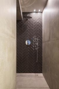 a bathroom with a shower with black tiles at Borgo De Chiari in Bologna