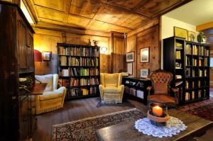 a living room filled with furniture and bookshelves at Hotel Montana in Madonna di Campiglio