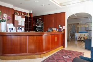 a wooden bar in a lobby with a counter at Sammartano Hotels in Marsala