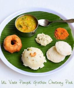 un plato de diferentes tipos de alimentos en una hoja de plátano en Jeyam Residency, en Dindigul