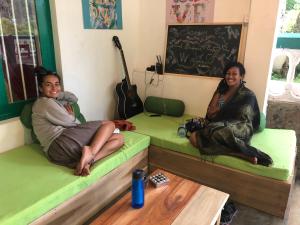 two women sitting on beds in a room at Ella Escapade Hostel by Nomadic in Ella