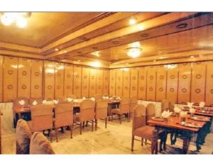 a dining room with tables and chairs in it at Comfortable Rooms Fitted With Modern Amenities in Nainital