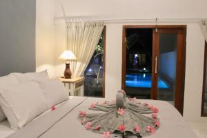 een kamer met een bed met bloemdecoratie bij Gili Inlander in Gili Trawangan