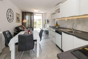 a kitchen with a table and chairs and a kitchen with a sink at Apartments Medora in Rovinj