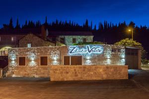 a building with a sign on it at night at Konavle Apartments Zlatovisce in Gruda