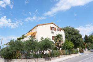 una casa blanca al lado de una calle en Apartman Balancana, en Kaštela