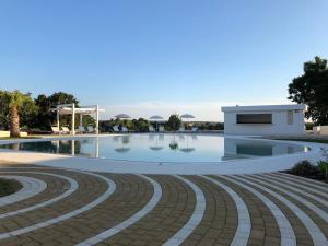 a swimming pool with a building in the background at Grotta Cilicia B&B in Noci