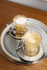 two cups of coffee on a plate on a table at Greta Residence in Zadar