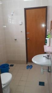 a bathroom with a toilet and a sink and a door at Faeyz Homestay Melaka in Melaka
