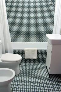 a bathroom with a toilet and a sink and a tub at Historical Porto/Gaia Apartment in Porto