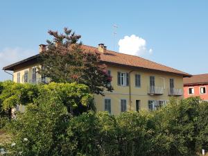 un edificio giallo con alberi di fronte di Locanda Ferro UNO, Golf Città di Asti ad Asti