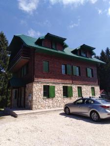 een huis met een auto ervoor geparkeerd bij Apartments Durmitor in Žabljak