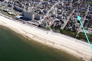 an aerial view of a beach with a blue flag at Gartensuite No.5@Haus Mateika in Westerland (Sylt)