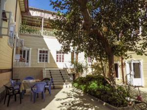 a patio with a table and chairs next to a building at Diyor Guest house in Bukhara