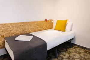 um quarto com uma cama com uma almofada amarela em Duc Allotjament em La Seu d'Urgell