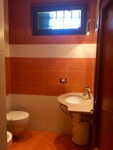 a bathroom with a toilet and a sink and a window at La Casina di Eleonora in Mosciano