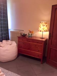 a bedroom with a dresser with a lamp on it at La Casina di Eleonora in Mosciano