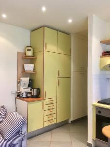 a kitchen with green cabinets and a microwave at La Casina di Eleonora in Mosciano