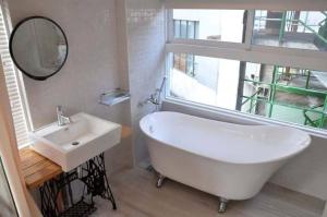 台南的住宿－Jami Homestay，一间带水槽、浴缸和镜子的浴室